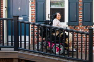 Suria, a wheelchair user, is on a ramp to access her home.