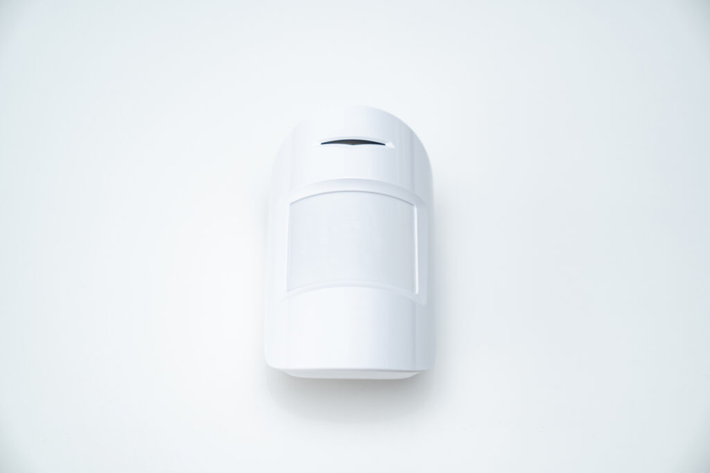 A smart motion sensor against a white wall.