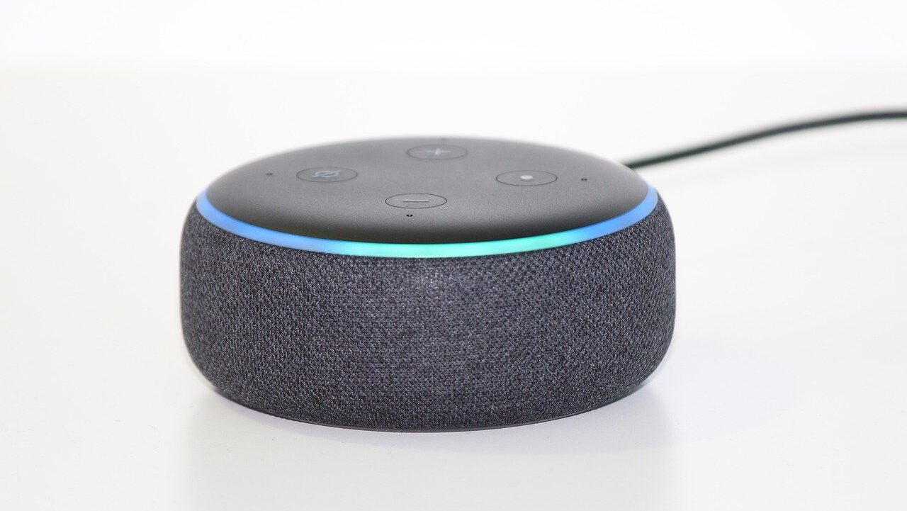 A lit-up, gray Amazon Echo Dot on a white background.